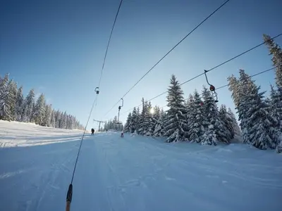 a ski lift on a snow covered slope with trees at Apartments Panda in Vlasic