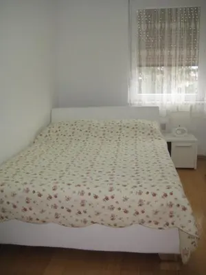 a bedroom with a bed with a floral bedspread at Apartment MA in Banja Luka