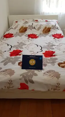 a bed with a comforter with a sign on it at Apartment MA in Banja Luka
