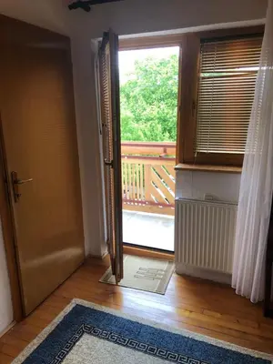 an open door leading to a balcony with a view of a deck at House Greda in Bihać