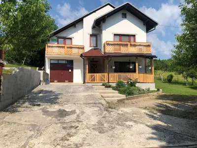a large white house with a driveway at House Greda in Bihać