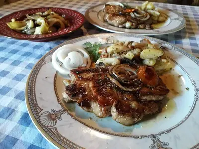 a plate of food with meat and vegetables on a table at Etno Selo Dodig in Drvar