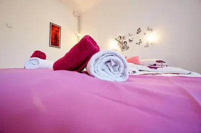 a pink bed with towels and stuffed animals on it at Central Tuzla apt - free parking in Tuzla