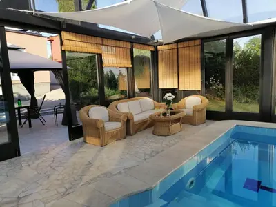 a swimming pool with chairs and a couch and a table at Deluxe Villa Coast River Sarajevo in Visoko