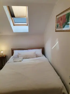a bed in a small room with a skylight at Deluxe Villa Coast River Sarajevo in Visoko