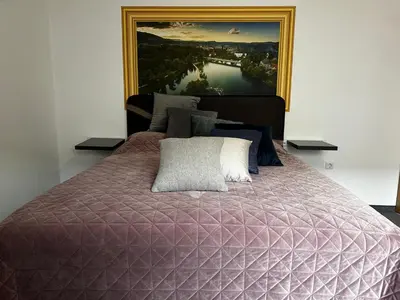a bedroom with a large bed with a painting on the wall at Motel Medium in Bihać