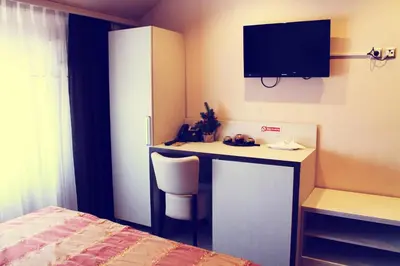 a bedroom with a desk with a tv and a bed at Motel Korzo in Bihać