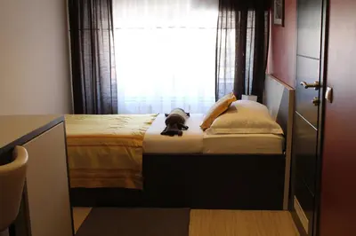 a dog sitting on a bed in front of a window at Motel Korzo in Bihać