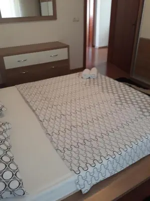 a bed with two white slippers on top of it at Apartman Anita in Livno