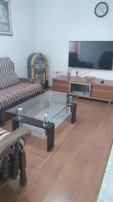 a living room with a glass coffee table and a tv at Apartman Anita in Livno
