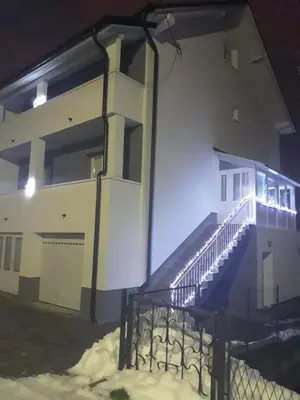 a building with a staircase in the snow at night at Apartman Anita in Livno
