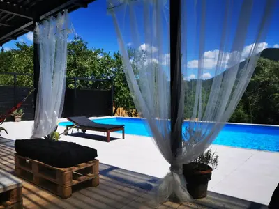 a patio with a swing and a pool at Mila Holiday Home in Lohovo