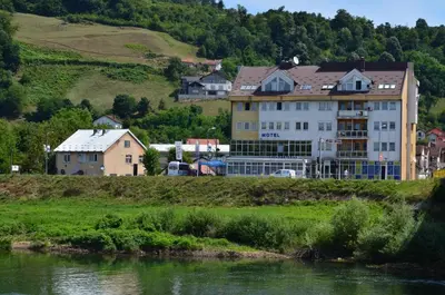 a large building on the side of a river at Motel New Sanatron in Bosanski Novi