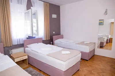 a room with three beds and a window at Motel New Sanatron in Bosanski Novi