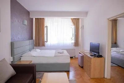 a hotel room with a bed and a tv at Motel New Sanatron in Bosanski Novi
