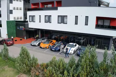 a group of cars parked in front of a building at Swiss Plus Hotel in Bihać