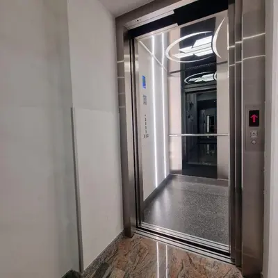 an elevator in a building with a glass door at Swiss Plus Hotel in Bihać