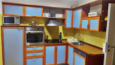 a kitchen with wooden cabinets and a white refrigerator at Apartment Vila Tara in Bihać