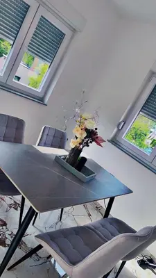 a dining room table with a vase of flowers on it at Apartment Vila Tara in Bihać