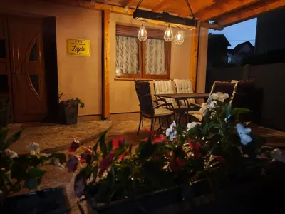 a patio with a table and chairs and flowers at House Leyla in Bihać