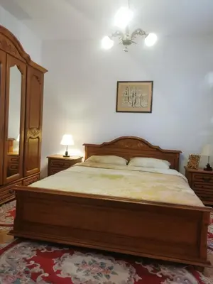 a bedroom with a large wooden bed and a mirror at House Leyla in Bihać