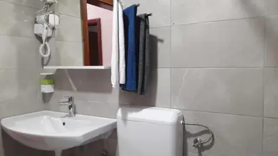 a bathroom with a sink and a toilet and a mirror at Honey Apartments in Visoko