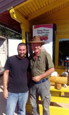 two men posing for a picture in front of a store at Honey Apartments in Visoko