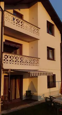 a building with a balcony on the side of it at Honey Apartments in Visoko