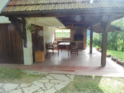 a patio with a table and chairs under a roof at Holiday Home Alibegović in Visoko