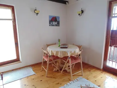 a dining room with a table and chairs in a room at Holiday Home Alibegović in Visoko
