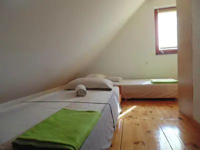 two beds in a attic room with a window at Holiday Home Alibegović in Visoko