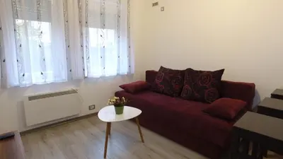 a living room with a red couch and a table at Apartman 