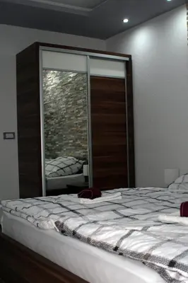 a bedroom with a large bed and a window at Apartman 