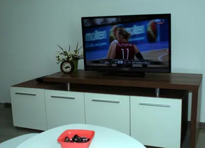 a flat screen tv sitting on top of a table at Apartman 