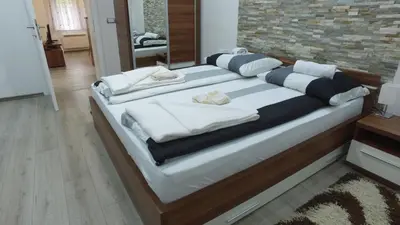 a bed with white pillows on it in a room at Apartman 