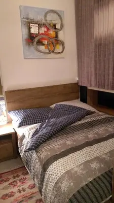 a bedroom with a bed and a painting on the wall at Guesthouse Jelic in Teslić