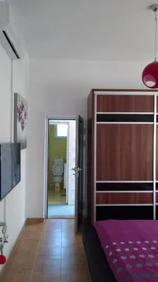 a bedroom with a bed and a bathroom with a toilet at Guesthouse Jelic in Teslić