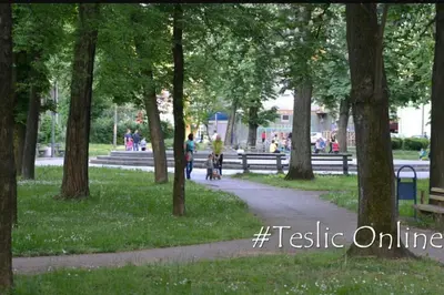 a path in a park with trees and people at Guesthouse Jelic in Teslić