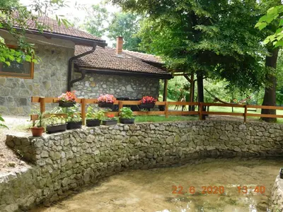 a stone retaining wall with potted plants on it at Apartment Green Lagoon in Bihać
