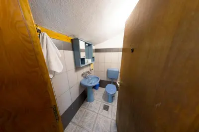 a bathroom with a blue toilet and a door at Apartment Green Lagoon in Bihać
