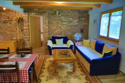 a living room with blue couches and a brick wall at Apartment Green Lagoon in Bihać
