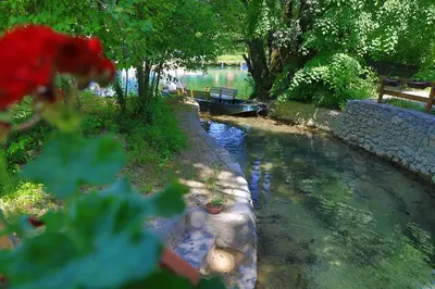 a view of a river with a boat in it at Apartment Green Lagoon in Bihać