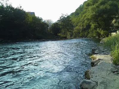 a river with rocks and trees on the side at holiday home RIVER HOUSE in Jajce