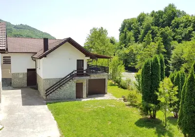 a house with a driveway and a yard at holiday home RIVER HOUSE in Jajce