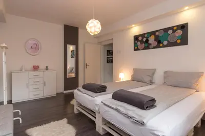 a bedroom with two beds and a chandelier at Apartment Amra in Visoko