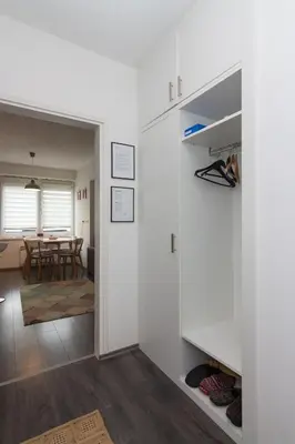 a room with white walls and a dining room with a table at Apartment Amra in Visoko