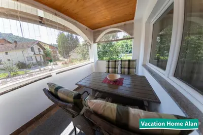 a screened in porch with a table and a couch at Vacation home Alan in Kulen Vakuf