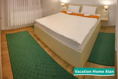 a bed in a room with green rugs at Vacation home Alan in Kulen Vakuf