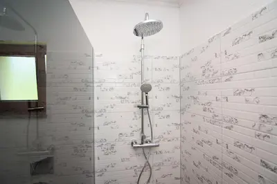 a shower in a bathroom with writing on the wall at Holiday Home Faruk in Račić