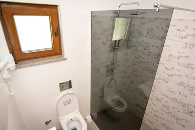 a bathroom with a shower and a toilet and a window at Holiday Home Faruk in Račić